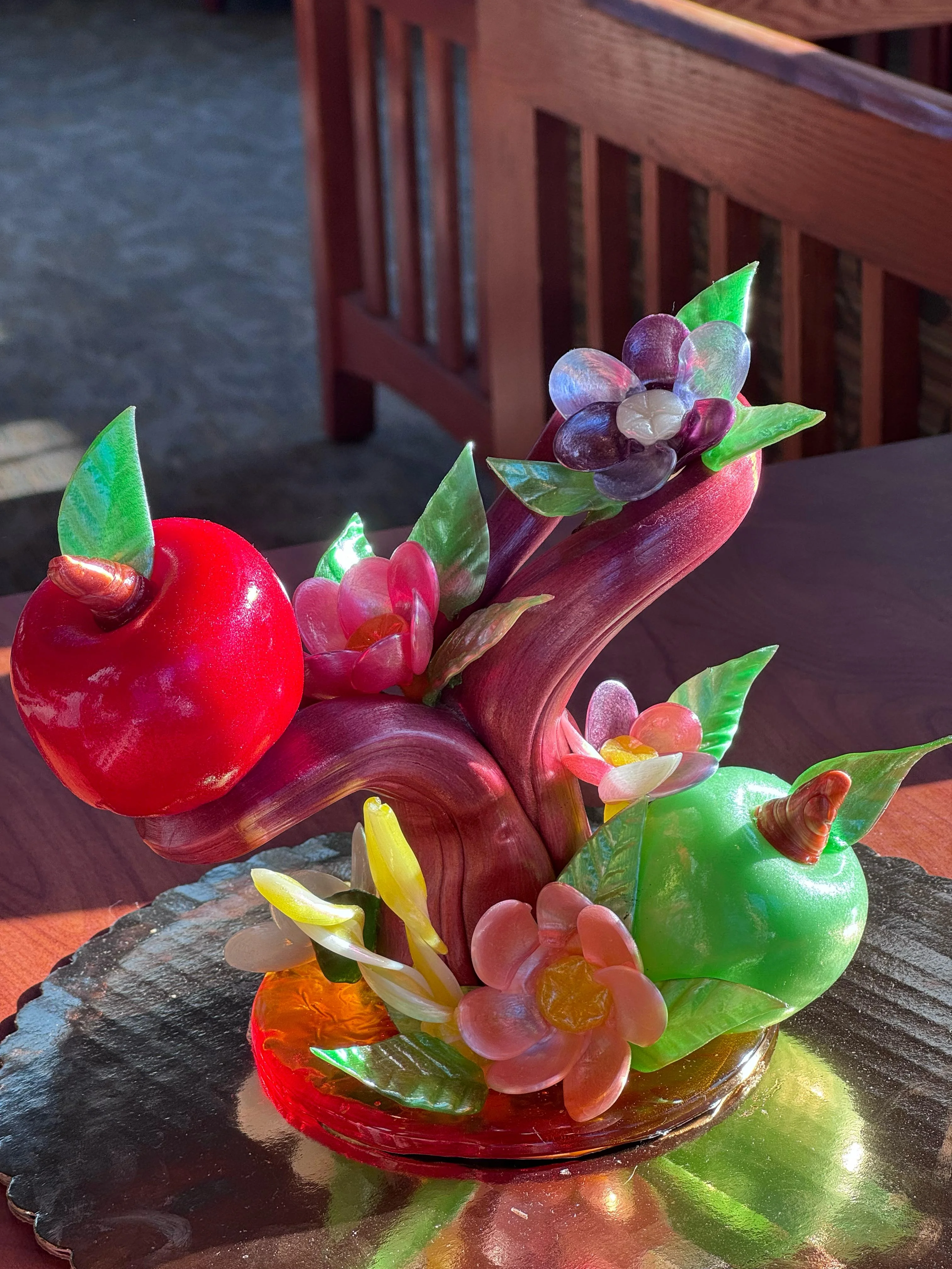 Verger — pulled-sugar still life with fruits and blossoms on a bough, presented in afternoon light